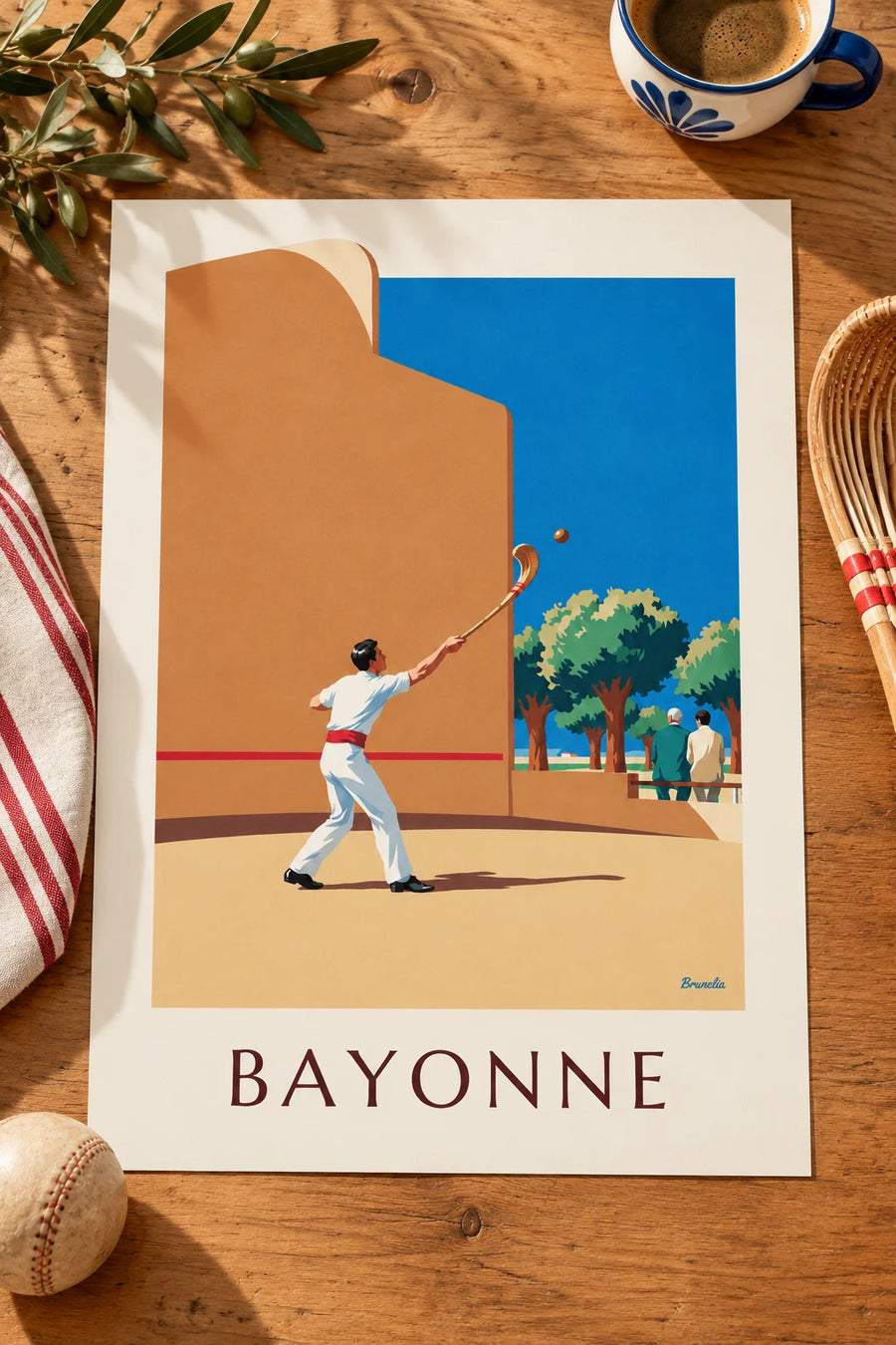 Affiche pelote basque à chistera devant le fronton de Bayonne : posée sur une table