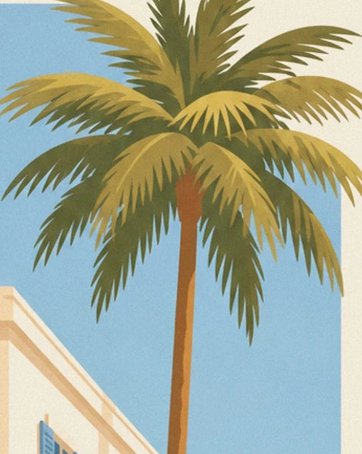 Die langen grünen und goldenen Wedel einer Palme vor dem blauen Himmel von Nizza