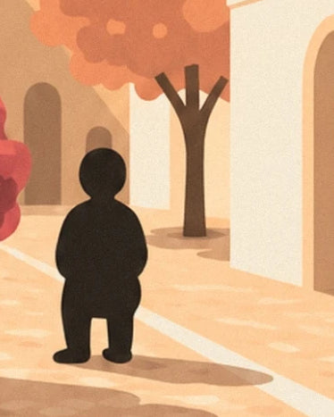 A black figure in the sunlit street between an orange tree and cream façades