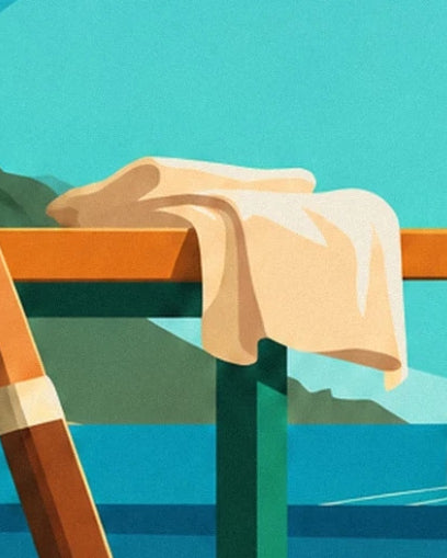 The cream towel draped over the orange crossbar of a bench facing the sea