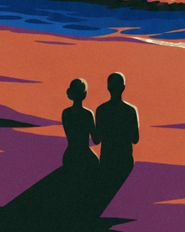 A couple in silhouette on the orange sand, with long purple shadows