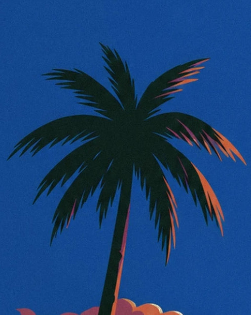 A dark palm tree with coral-edged fronds against a deep blue sky