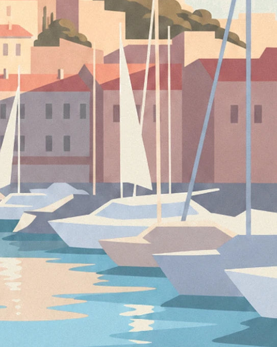 White sailing boats moored in front of the harbour's pink and ochre façades