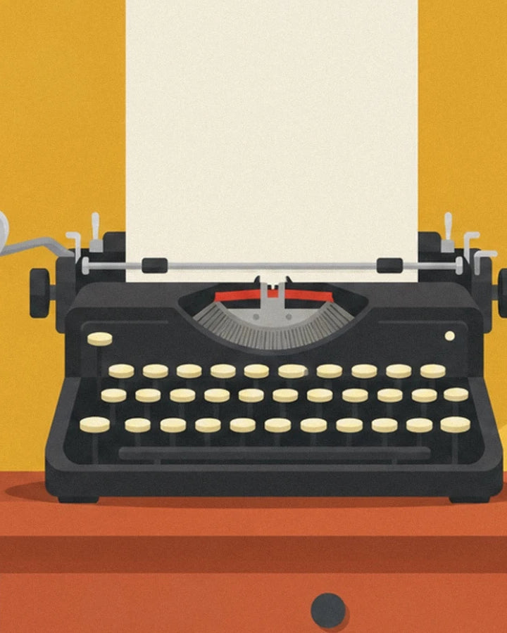 The black typewriter with cream keys and its white sheet of paper on the desk