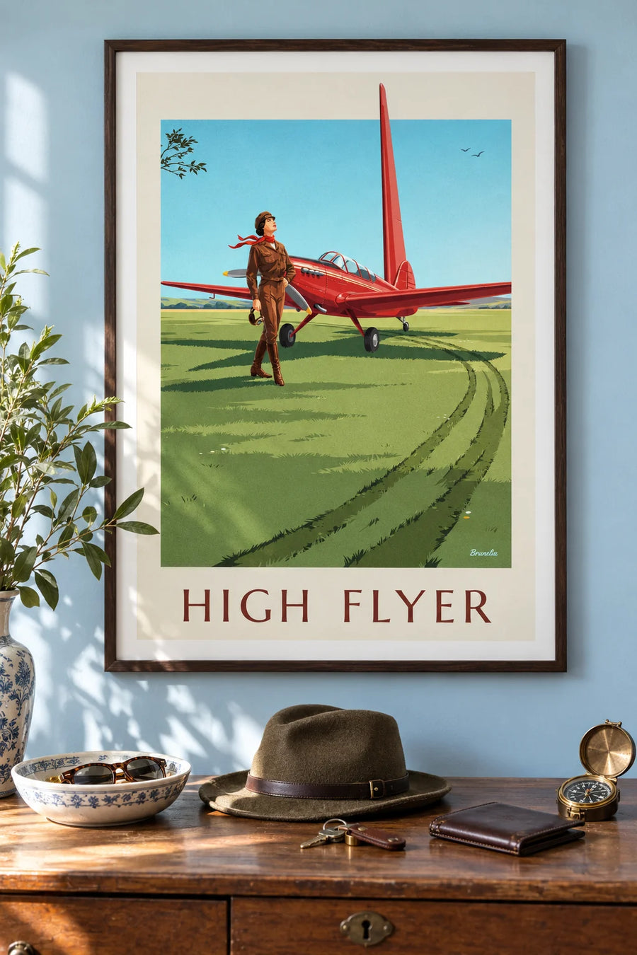 Affiche aviatrice et avion à hélice rouge sur une piste en herbe : encadrée au mur